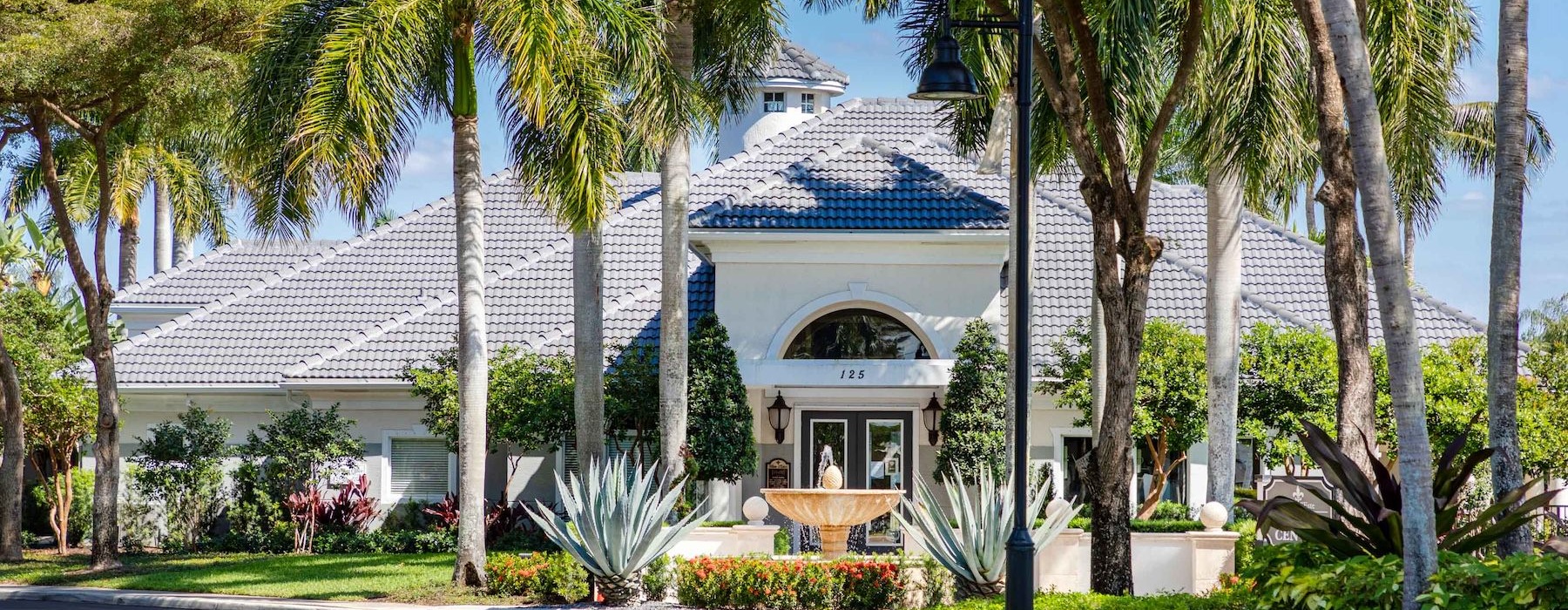 a white house with trees and a street