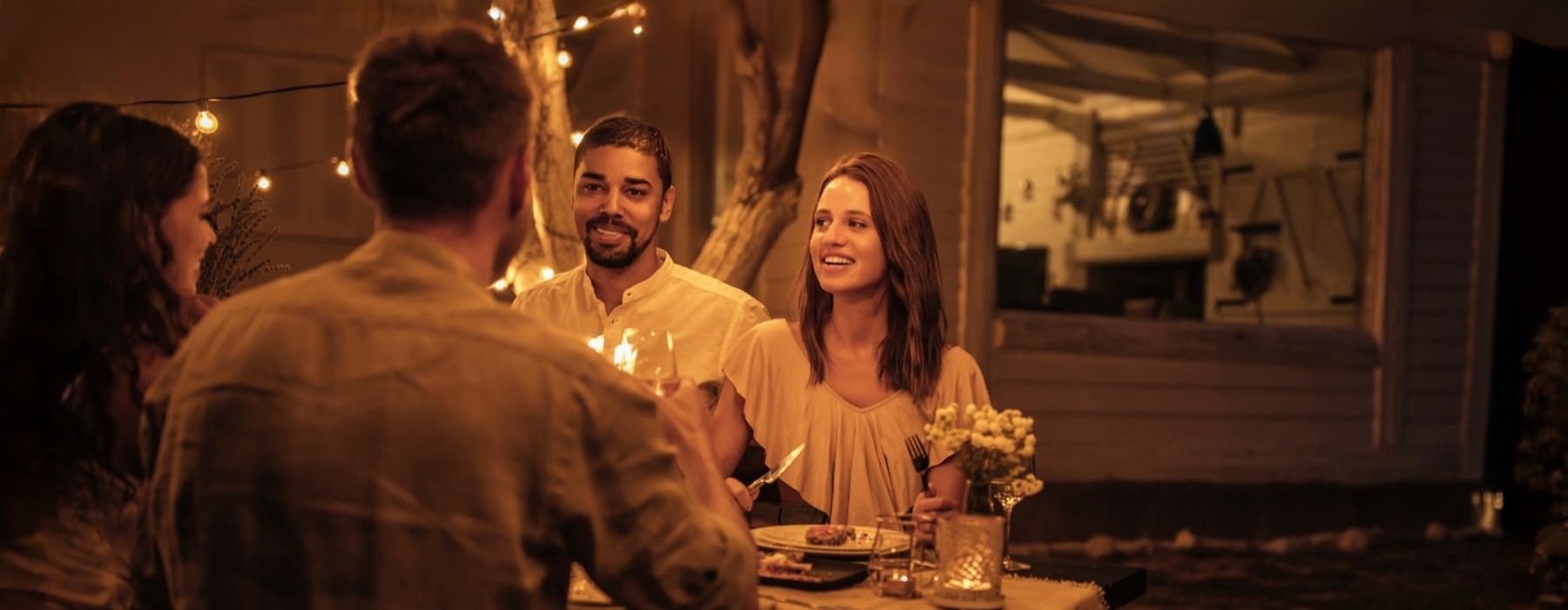 people sitting at a table with food and drinks